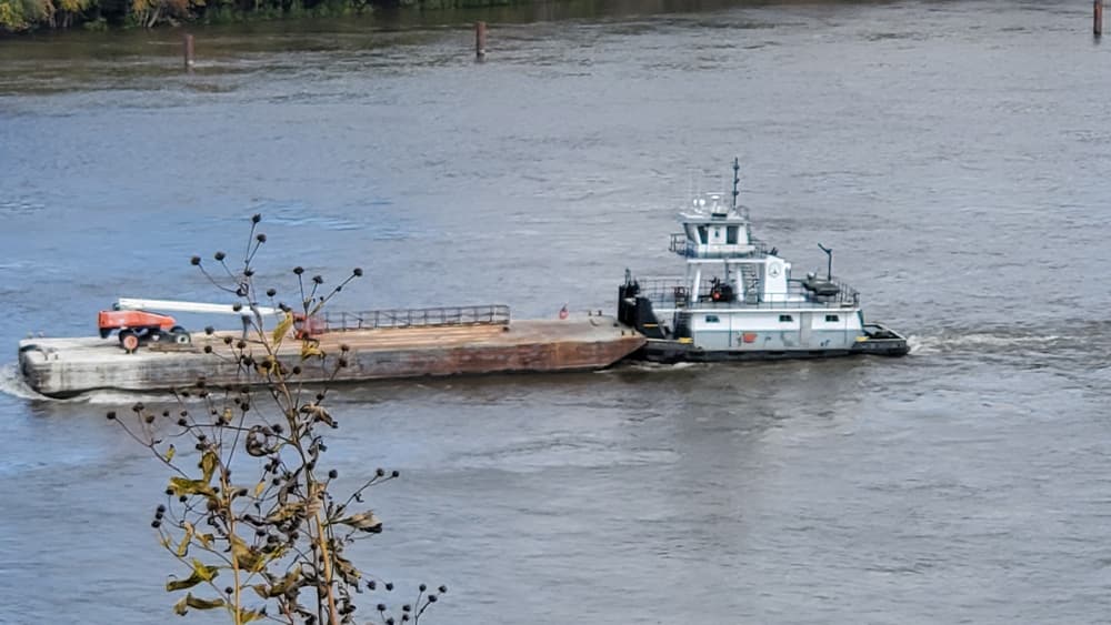 Tugboat with barge on water