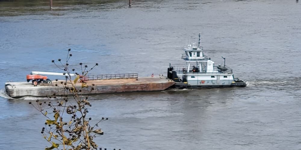 Tugboat with barge on water