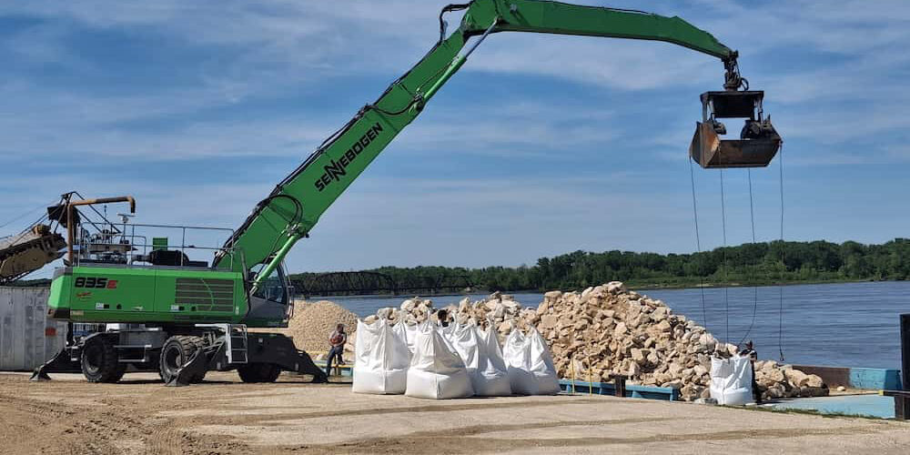 Crane lifting rocks in bags